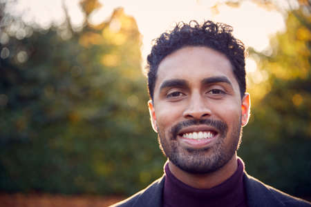 Portrait Of Smiling Young Man Enjoying Outdoor Walk In Fall Or Winter Countrysideの写真素材