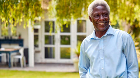 Portrait Of Relaxed Senior Man Standing In Garden At Home After Retirementの写真素材