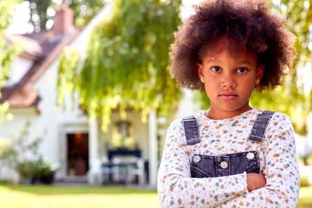 Portrait Of Sassy Young Girl With Attitude Standing In Garden At Home After Retirementの写真素材