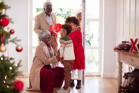 Grandchildren Greeting Grandparents As They Arrive With Presents To Celebrate Christmas