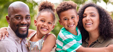 Portrait Of Smiling Family At Home Outdoors In Garden Together