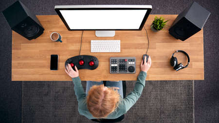 Overhead View Of Female Video Editor Working At Computer In Creative Officeの写真素材