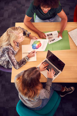 Overhead Shot Of University Or College Students Sitting Around Table With Tutor In Lessonの写真素材