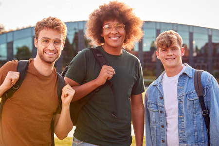 Portrait Of Three Male University Or College Student Standing Outdoors By Modern Campus Buildingの写真素材
