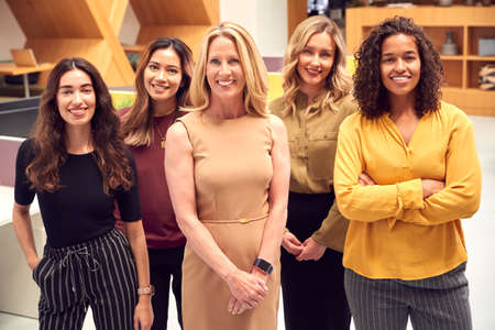 Portrait Of Multi-Cultural Female Business Team Standing In Modern Open Plan Officeの写真素材