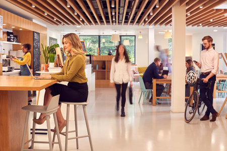 Interior Of Busy Office Coffee Shop With Businesspeople Working At Tablesの写真素材