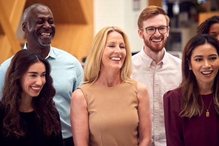 Portrait Of Smiling Multi-Cultural Business Team Standing In Modern Open Plan Officeの写真素材
