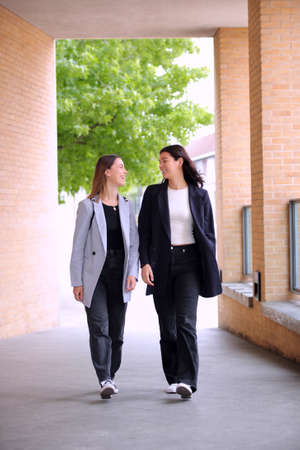Two Young Businesswomen Walking To Work In Office Togetherの写真素材