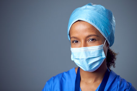 Studio Portrait Of Female Surgeon Wearing Scrubs And Face Maskの写真素材