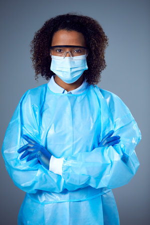 Studio Portrait Of Female Lab Worker in PPE With Face Mask And Safety Glassesの写真素材