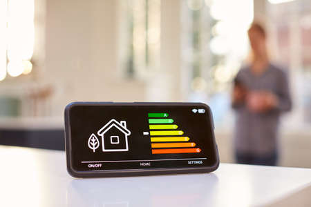 Smart Energy Meter In Kitchen Measuring Energy Efficiency With Figure In Backgroundの写真素材