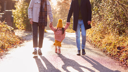Family With Two Dads Taking Daughter For Walk In Fall Or Winter Countrysideの写真素材