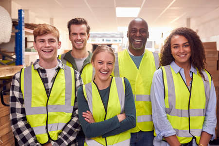 Portrait Of Multi-Cultural Team Wearing Hi-Vis Safety Clothing Working In Modern Warehouseの写真素材
