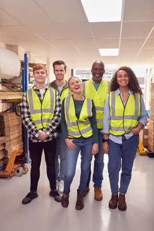 Portrait Of Multi-Cultural Team Wearing Hi-Vis Safety Clothing Working In Modern Warehouseの写真素材