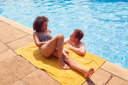 Romantic Couple Drinking Champagne In Swimming Pool On Vacationの写真素材