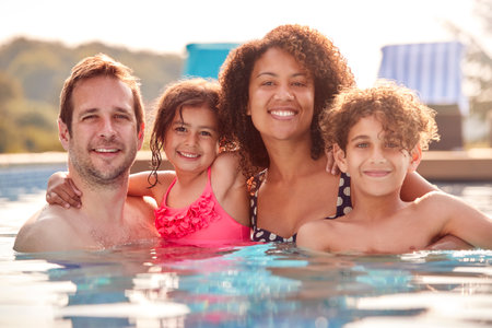 Portrait Of Family Having Fun In Swimming Pool On Summer Vacationの写真素材