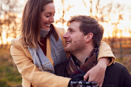 Portrait Of Romantic Couple With Woman With Prosthetic Hand Hugging in Winter Or Autumn Countryside
