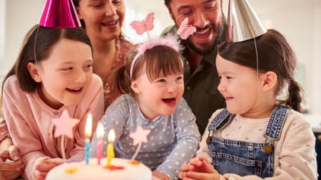 Family With Down Syndrome Daughter Celebrating Birthday With Party At Home Together