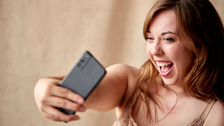 Studio Shot Of Body Positive Woman In Underwear Taking Selfie On Mobile Phoneの写真素材