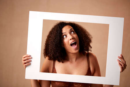 Studio Shot Of Confident Natural Woman In Underwear Promoting Body Positivity In Picture Frameの写真素材