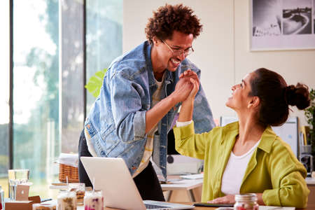Couple Running Online Business Making Boutique Candles At Home Celebrating With High Five