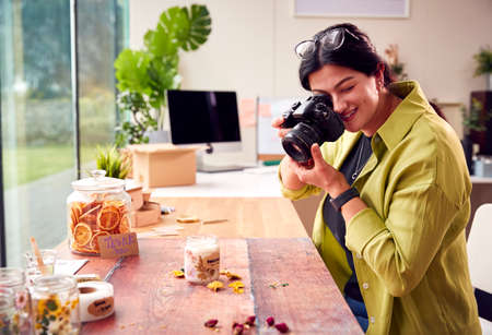 Woman Running Online Business Making Boutique Candles Taking Photos For Online Marketing