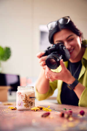 Woman Running Online Business Making Boutique Candles Taking Photos For Online Marketing