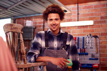 Portrait Of Man Running Business In Workshop At Home Restoring And Upcycling Furnitureの写真素材