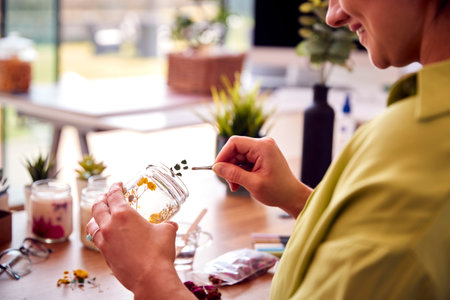 Close Up Of Woman Making Boutique Flower Candles To Sell Online Working From Homeの写真素材