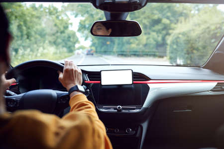 Close Up Of Driver With Hands Free Unit For Green Screen Mobile Phone Mounted On Dashboardの写真素材
