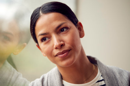 Head And Shoulders Portrait Of Woman Or Businesswoman Standing By Window In Office Or At Homeの写真素材