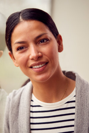 Head And Shoulders Portrait Of Woman Or Businesswoman Standing By Window In Office Or At Homeの写真素材