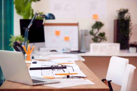 Empty Architects Office With Plans For New Building On Desk
