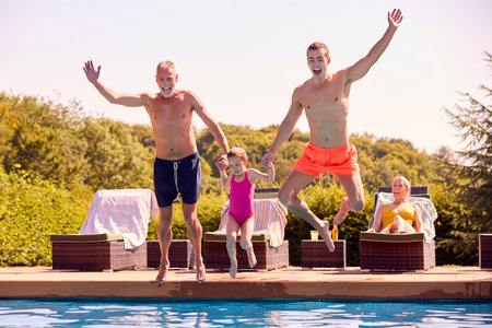 Multi-Generation Family On Summer Holiday Jumping Into Swimming Poolの写真素材