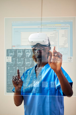 Female Nurse Or Doctor In Scrubs With VR Headset Interacting With AR Technology On Projected Screenの写真素材