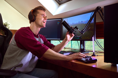Man Gaming At Home Wearing Wireless Headphones Sitting At Desk With Multiple Monitors
