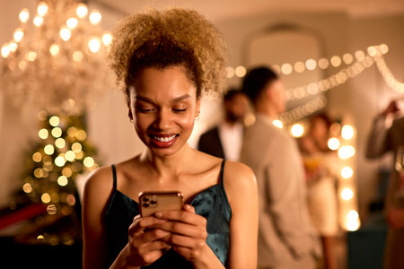 Woman At Party Checking Social Media Or Messages On Mobile Phoneの写真素材