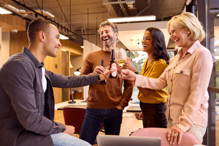 Staff At Informal Team Meeting In Office Celebrating With Drinksの写真素材