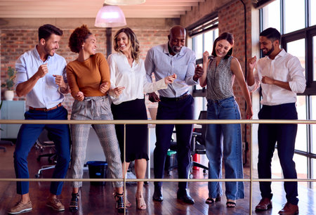 Relaxed Business Team Meeting In Busy Multi-Cultural Office With Colleagues Dancing And Having Fun