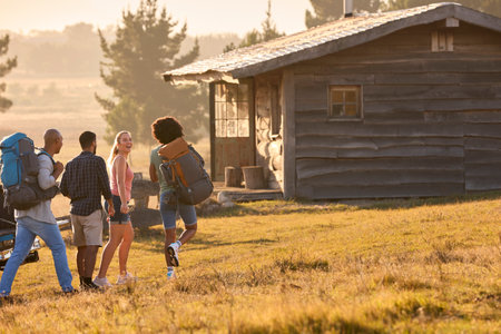 Group Of Friends Unloading Backpack From Pick Up Truck On Road Trip To Cabin In Countrysideの写真素材