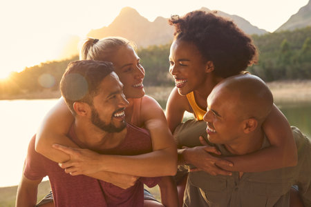 Outdoor Portrait Of Friends With Men Giving Women Piggybacksの写真素材