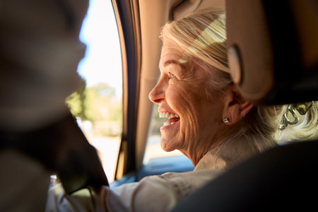 Smiling Senior Female Driver Looking Out Of Car Window Enjoying Day Trip Out Drivingの写真素材