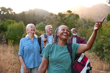 Group Of Senior Friends Enjoying Hiking Through Countryside Togetherの写真素材