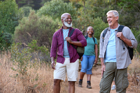 Group Of Senior Friends Enjoying Hiking Through Countryside Togetherの写真素材