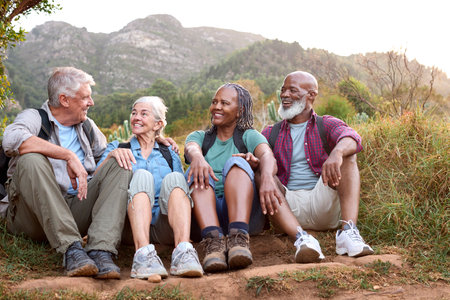 Active Senior Friends Sitting Taking A Break Hiking Through Countryside Togetherの写真素材