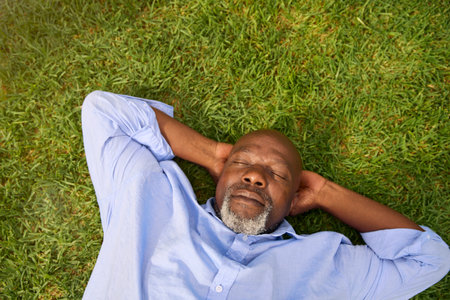 Overhead Shot Of Senior Man Sleeping On Grass Outdoors In Garden At Homeの写真素材