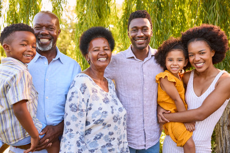 Portrait Of Multi-Generation Family Standing In Garden Smiling At Cameraの写真素材