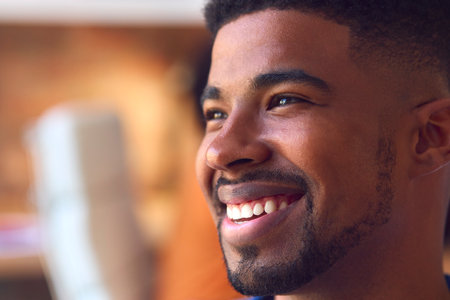 Close Up Portrait Of Smiling Young Businessman At Desk In Modern Office