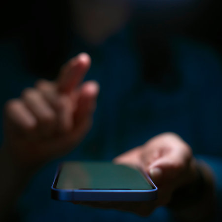 Close Up Of Woman Using Mobile Phone With Finger Poised Above Screen