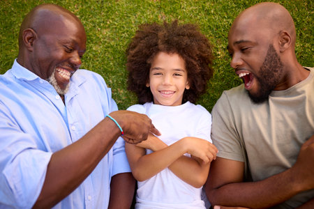 Overhead Shot Of Multi-Generation Male Family Lying On Grass Together